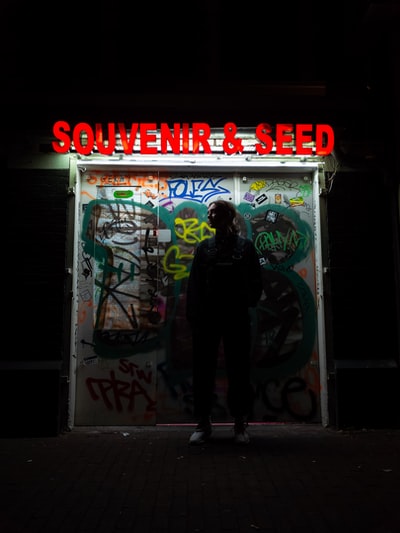 Stands behind the wall of graffiti tag women, covered with souvenirs and seed words on the wall
